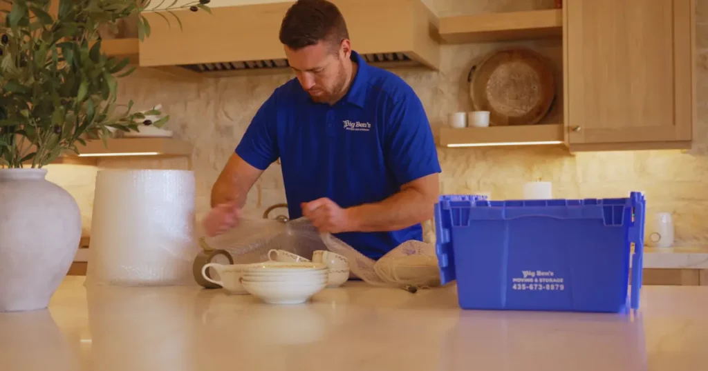 Big Ben’s Moving & Storage mover carefully packing kitchen items with protective bubble wrap